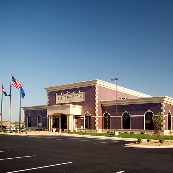 A large building with american flags in the background.