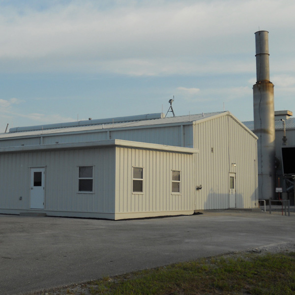 A large building with a smokestack in the background.