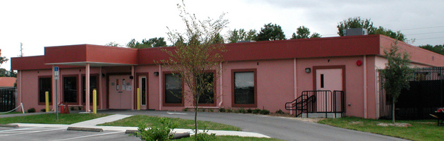 A pink building with red trim and windows.