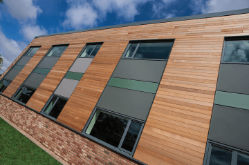 A building with wood siding and windows on the outside.
