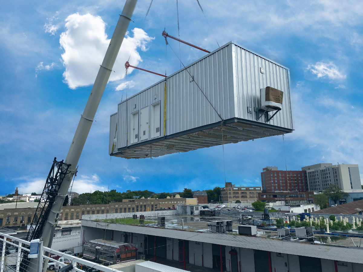 A crane lifting an air conditioner unit.