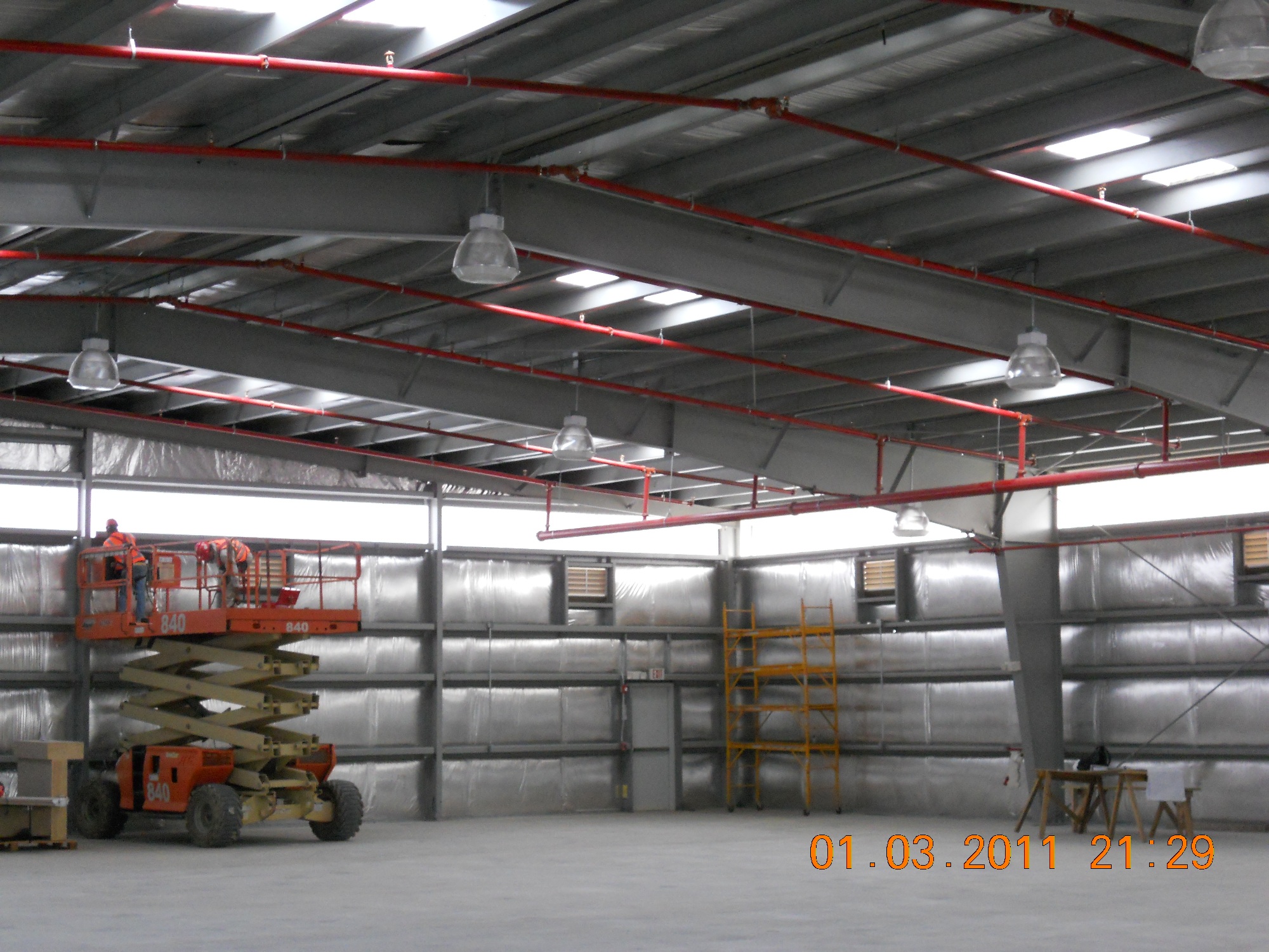 A warehouse with many stacks of metal pipes.