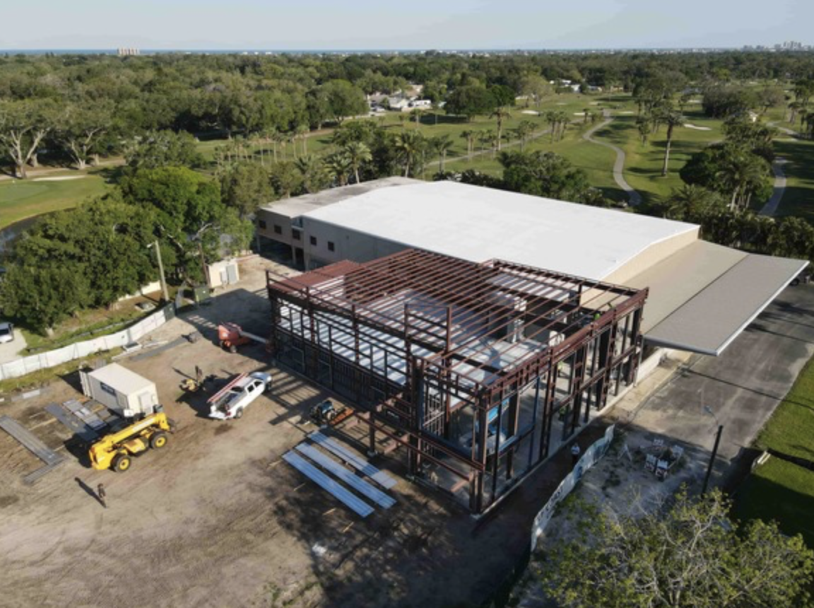A building that is being built in the middle of a field.
