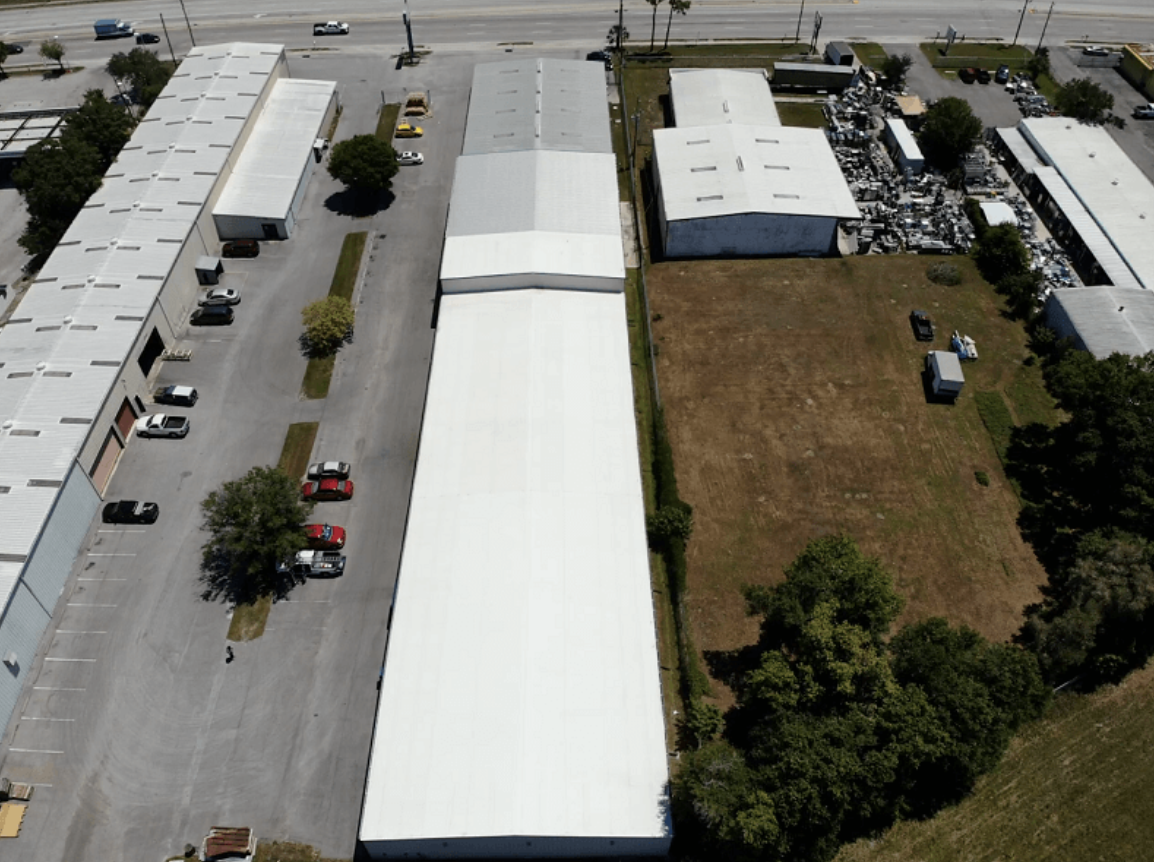 An aerial view of a large tent in the middle of a parking lot.